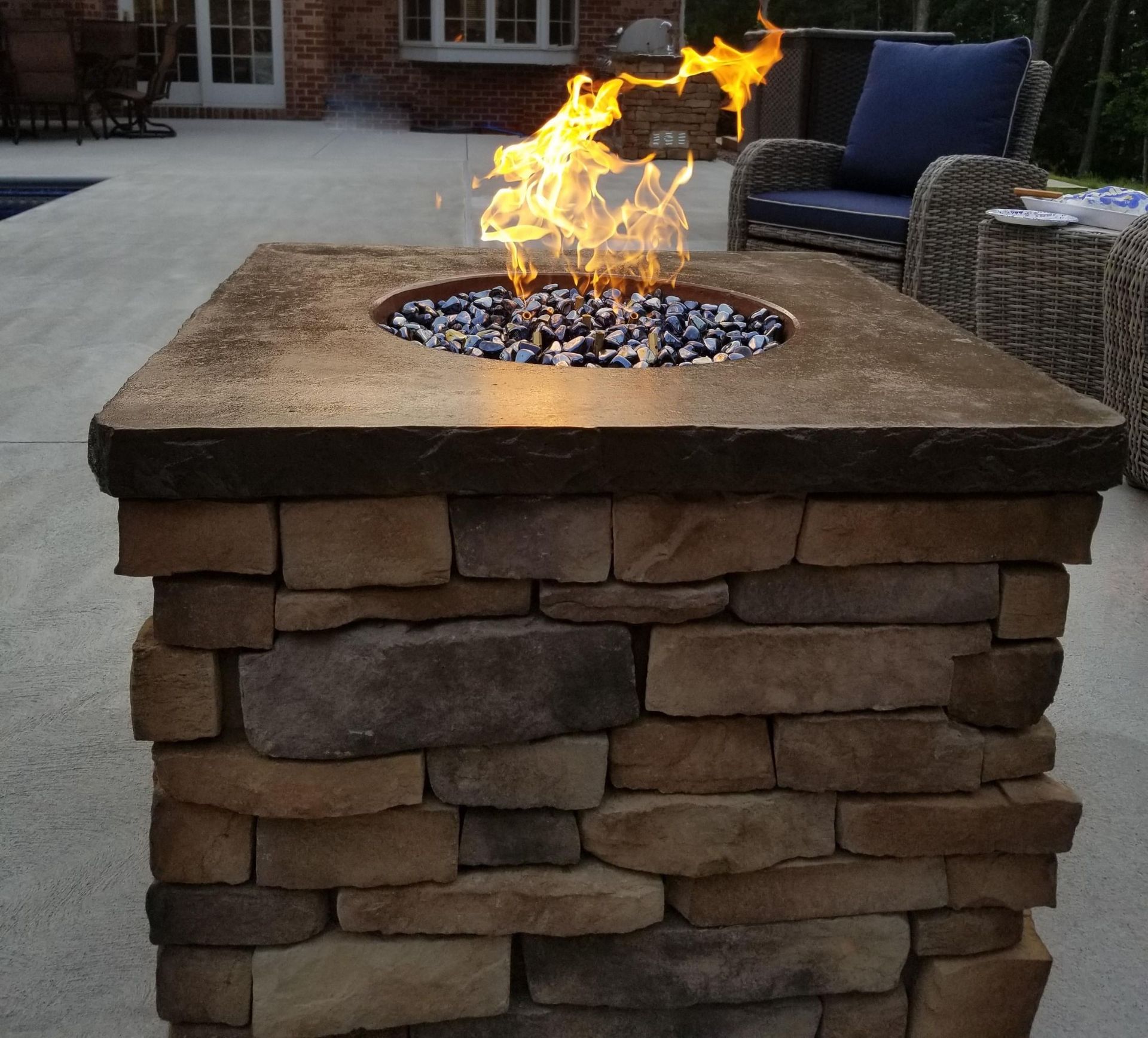 A fire pit made of bricks with a fire coming out of it