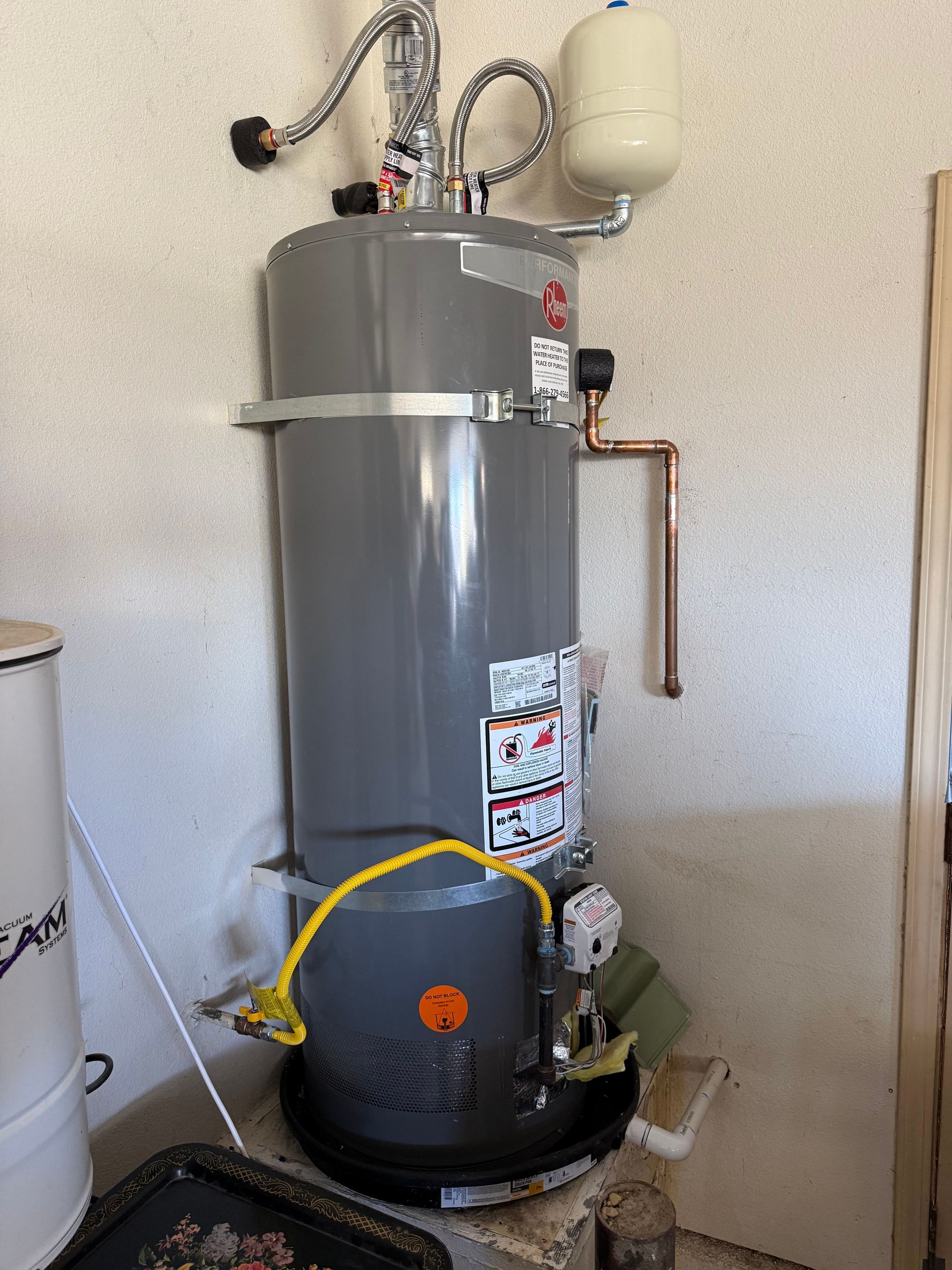 Gray water heater with pipes, expansion tank, and insulation in a utility room