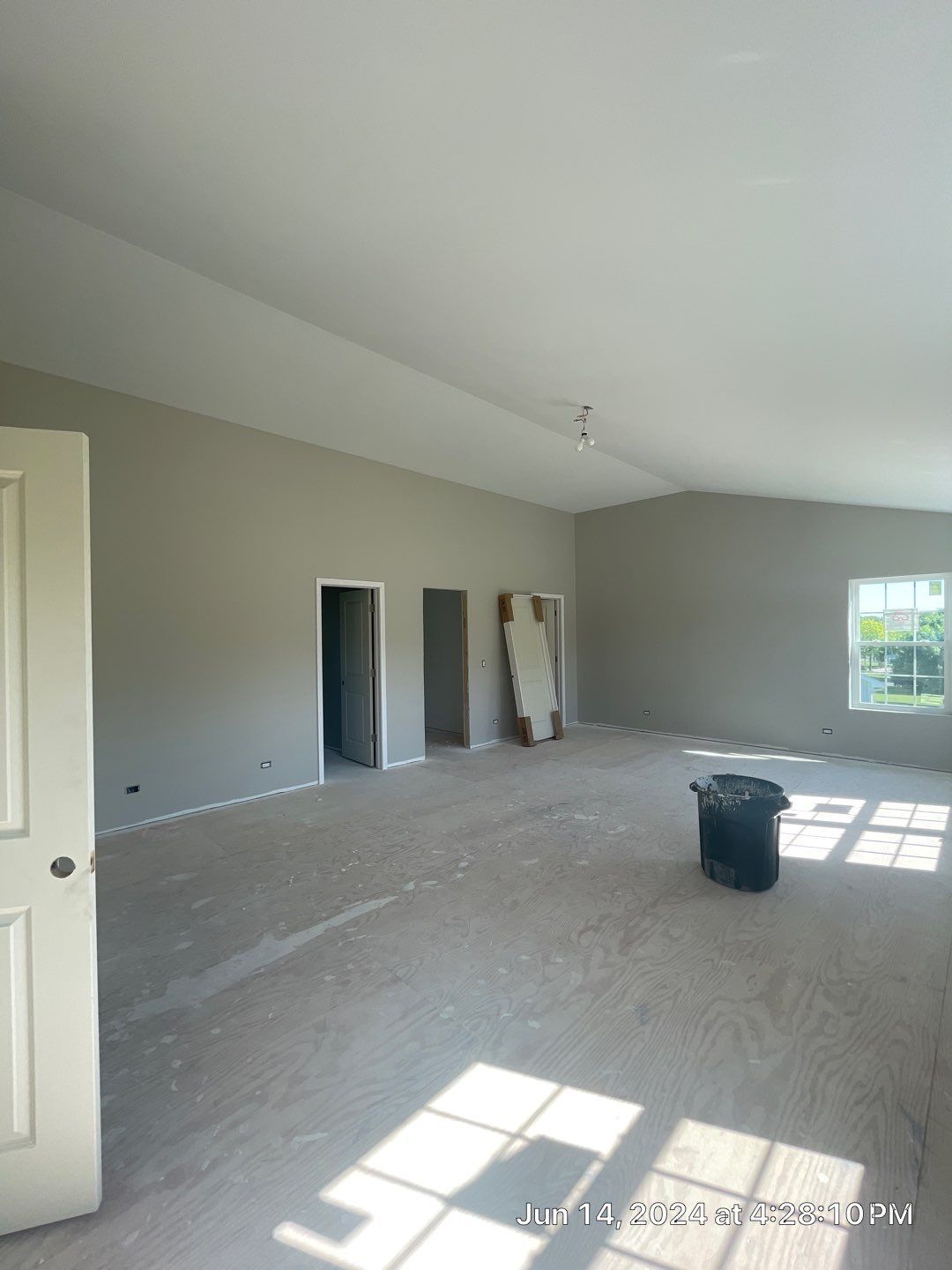 An empty room with a trash can in the middle of it