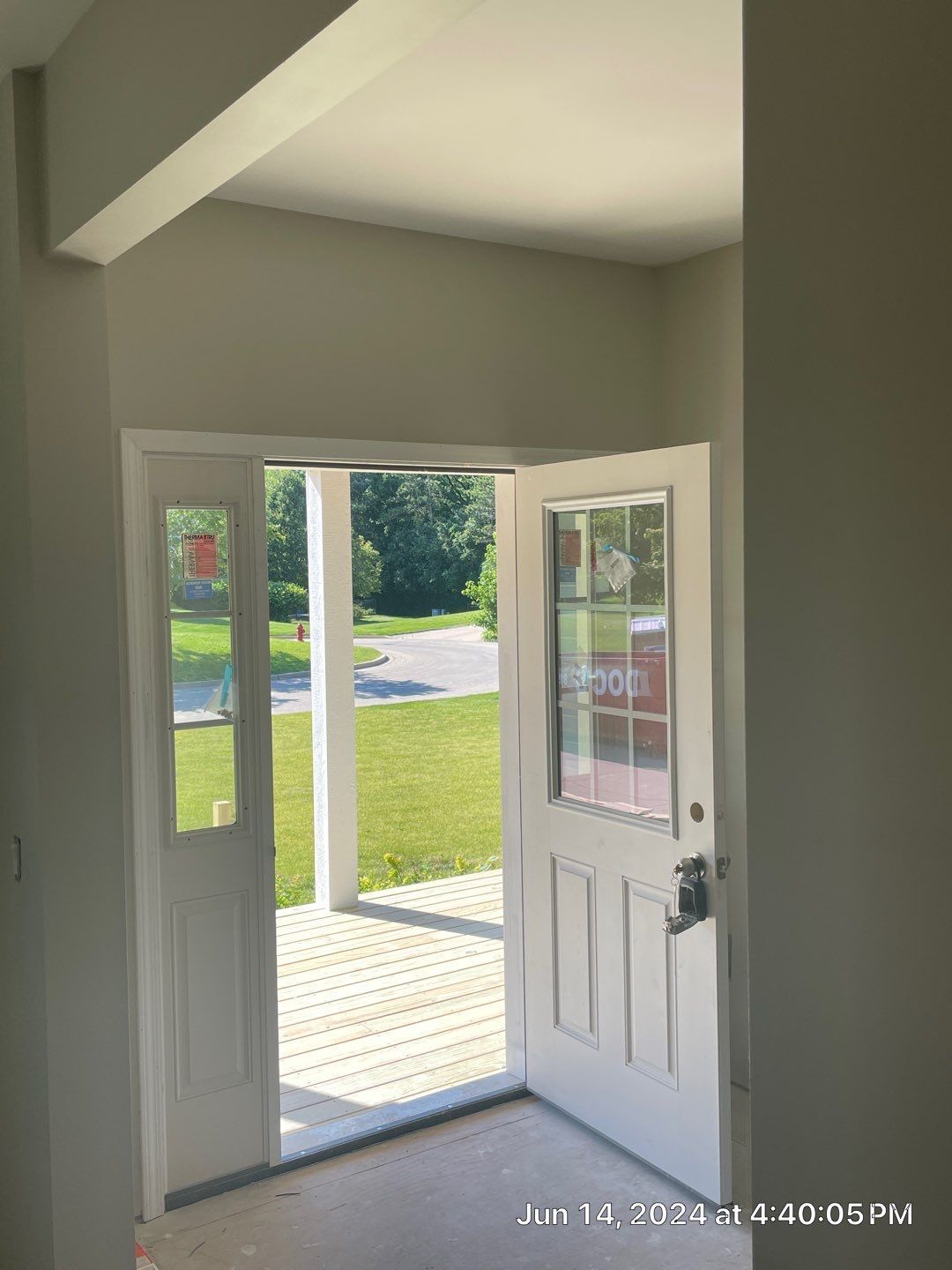 A white door is open to a porch in an empty room.
