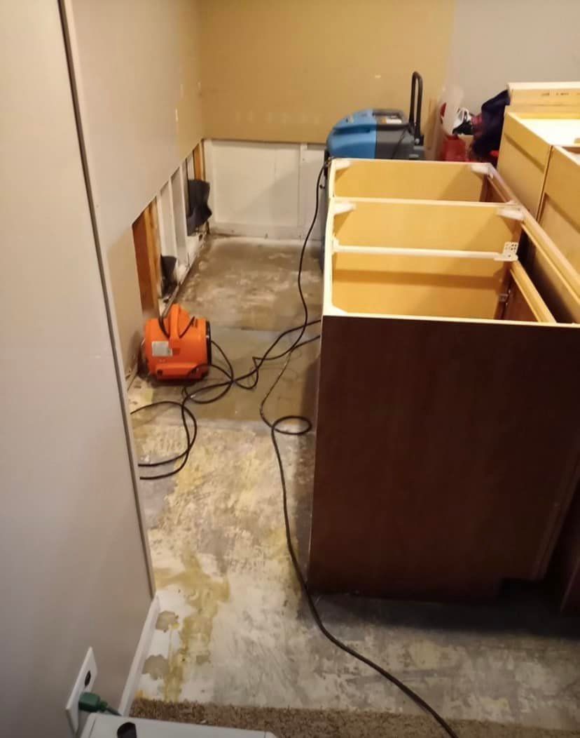 A vacuum is sitting on the floor next to a row of cabinets