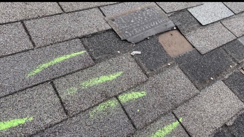 A close up of a roof with green chalk markings on it.