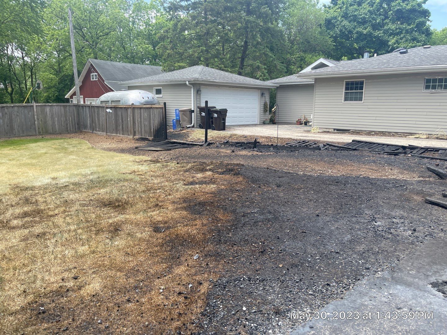 A house with a garage and a lot of dirt in front of it.