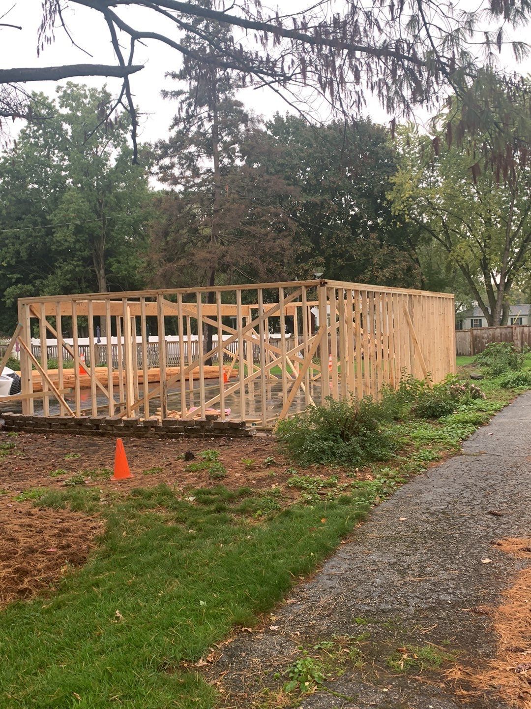 A large wooden structure is being built on the side of a road.