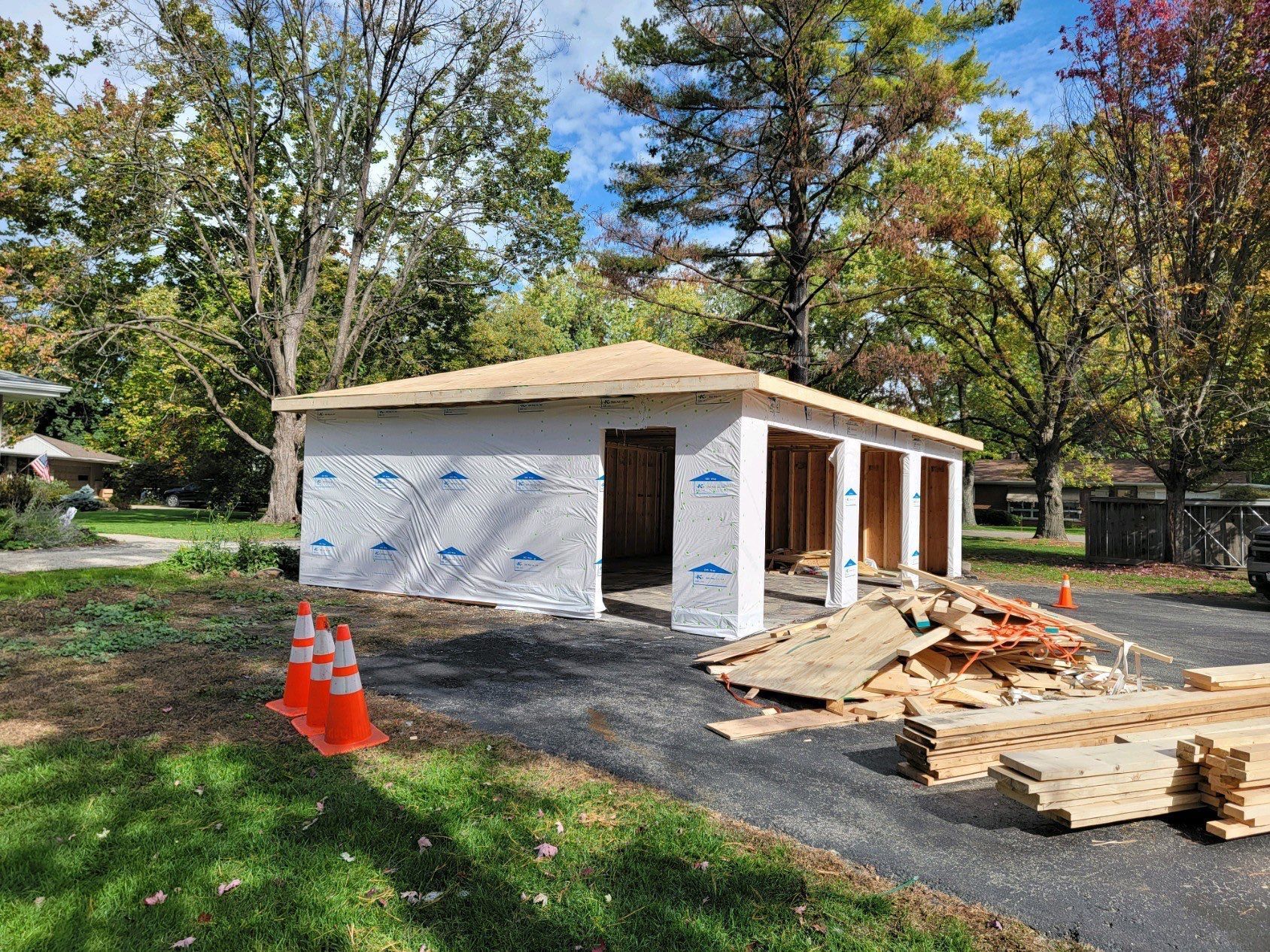 A garage is being built in the backyard of a house.