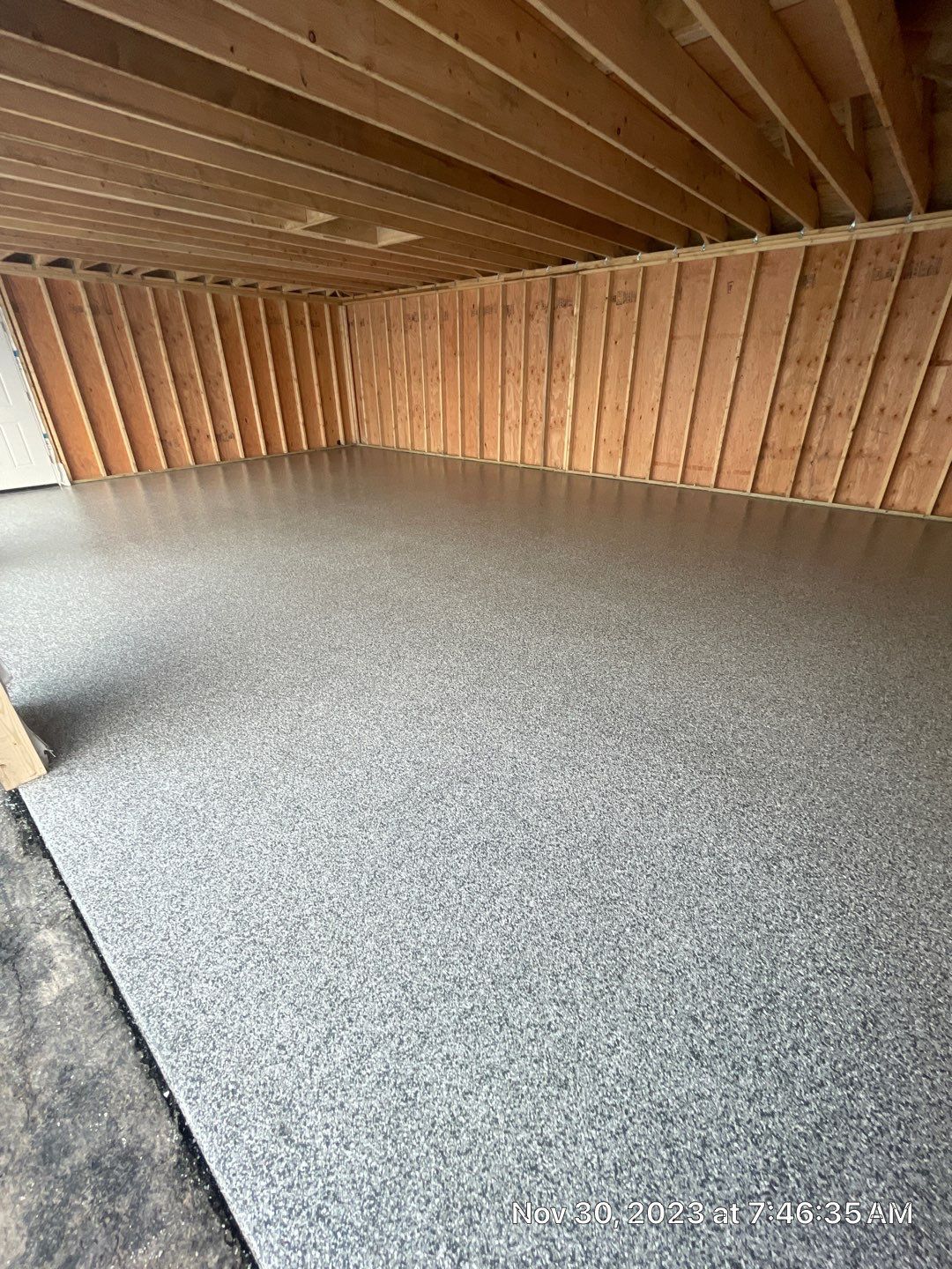 A garage with a concrete floor and wooden walls.