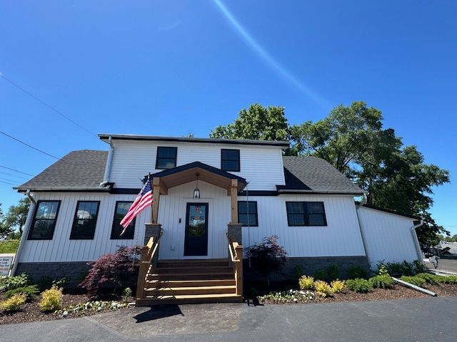 A white house with an american flag on the front porch