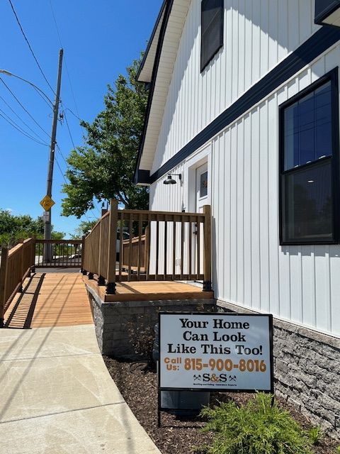 A white house with a sign that says your house can look like this too
