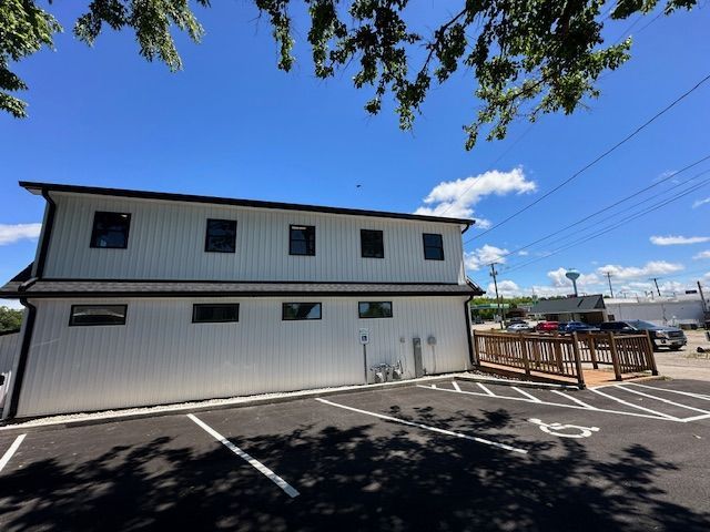 A white building with a handicapped parking spot in front of it