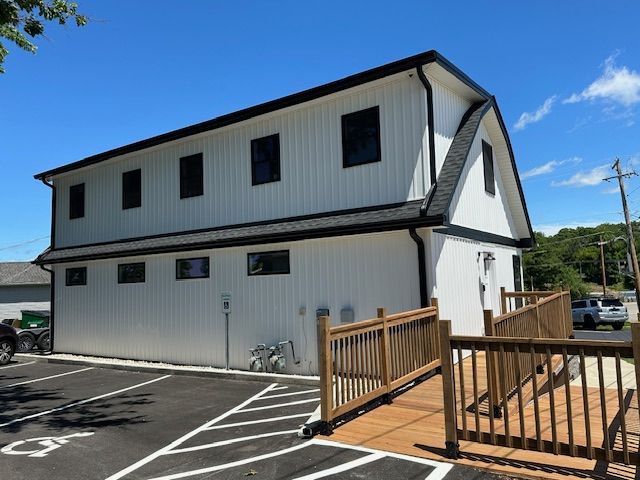A white building with a handicapped parking spot in front of it