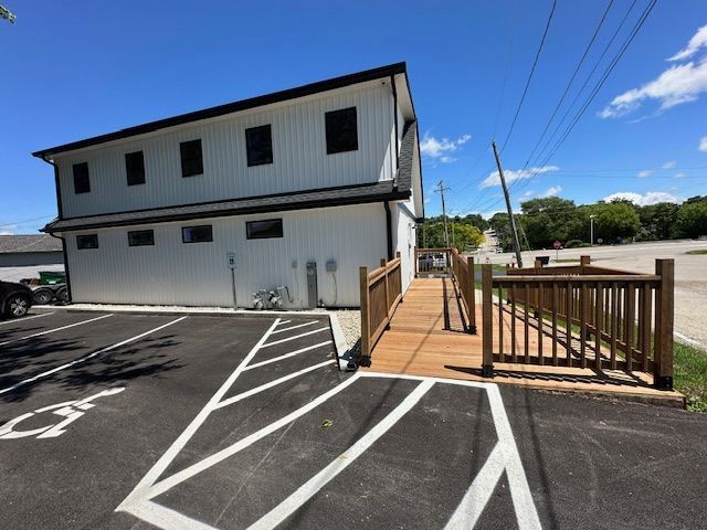 A handicapped parking spot next to a building with a ramp