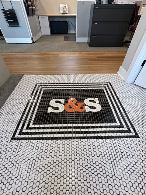 A black and white tile floor with the letters s & s on it
