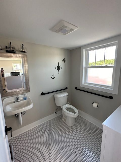 A bathroom with a toilet a sink and a window