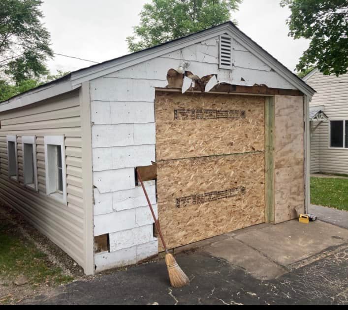 A white garage with a broom in front of it