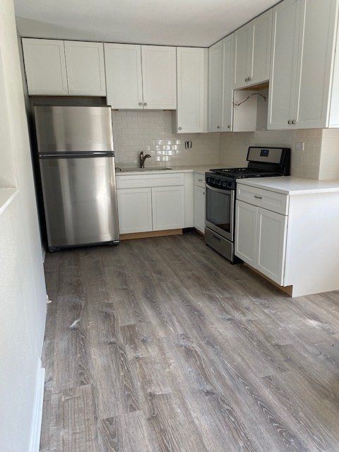 A kitchen with stainless steel appliances and white cabinets