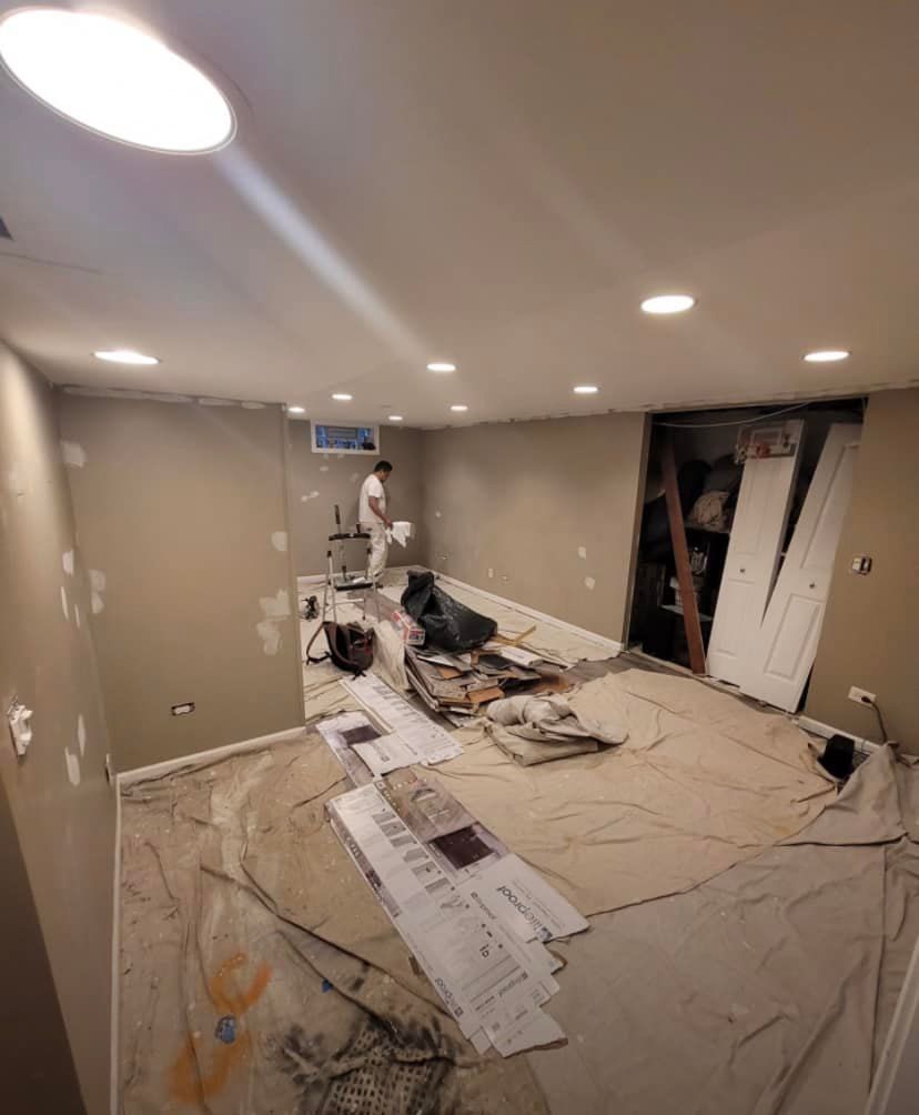 A man is standing in a room that is being painted.