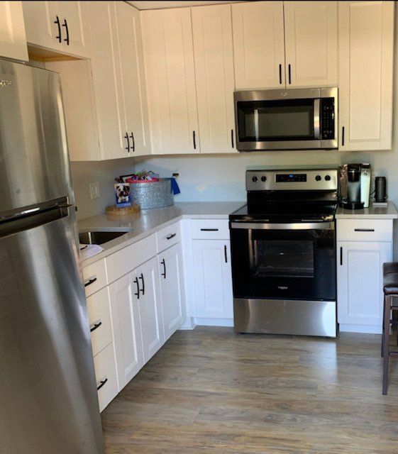 A kitchen with stainless steel appliances and white cabinets