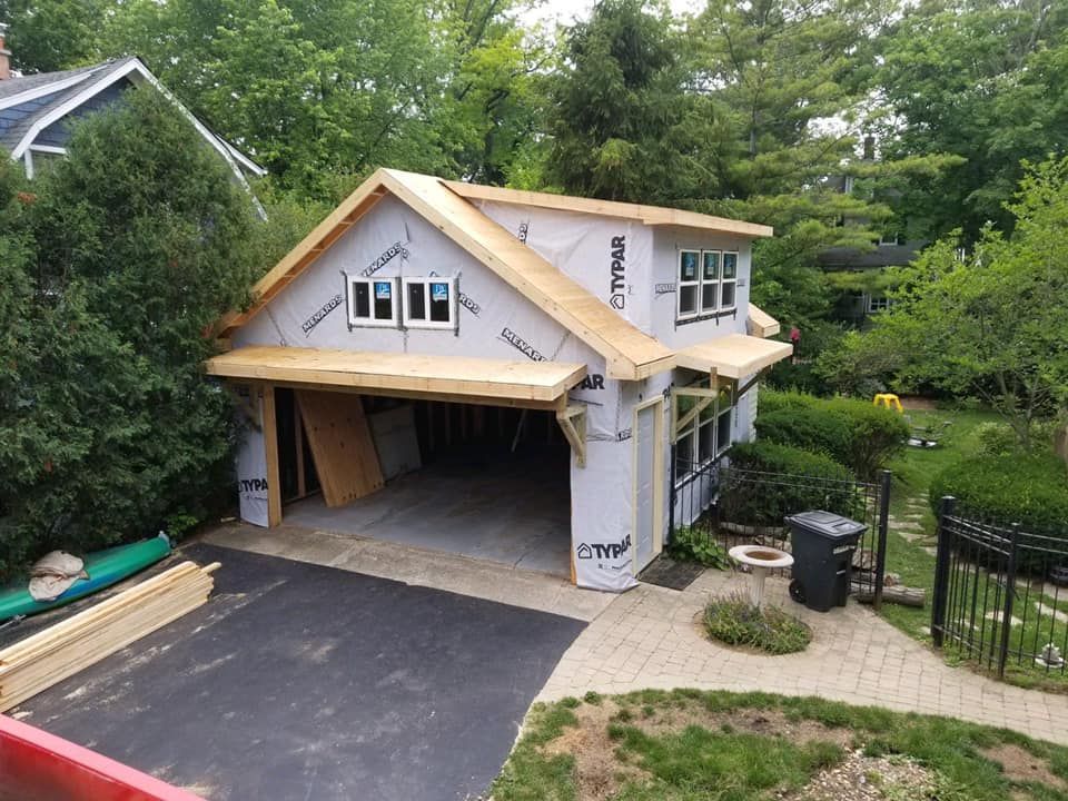 A garage is being built in the backyard of a house.