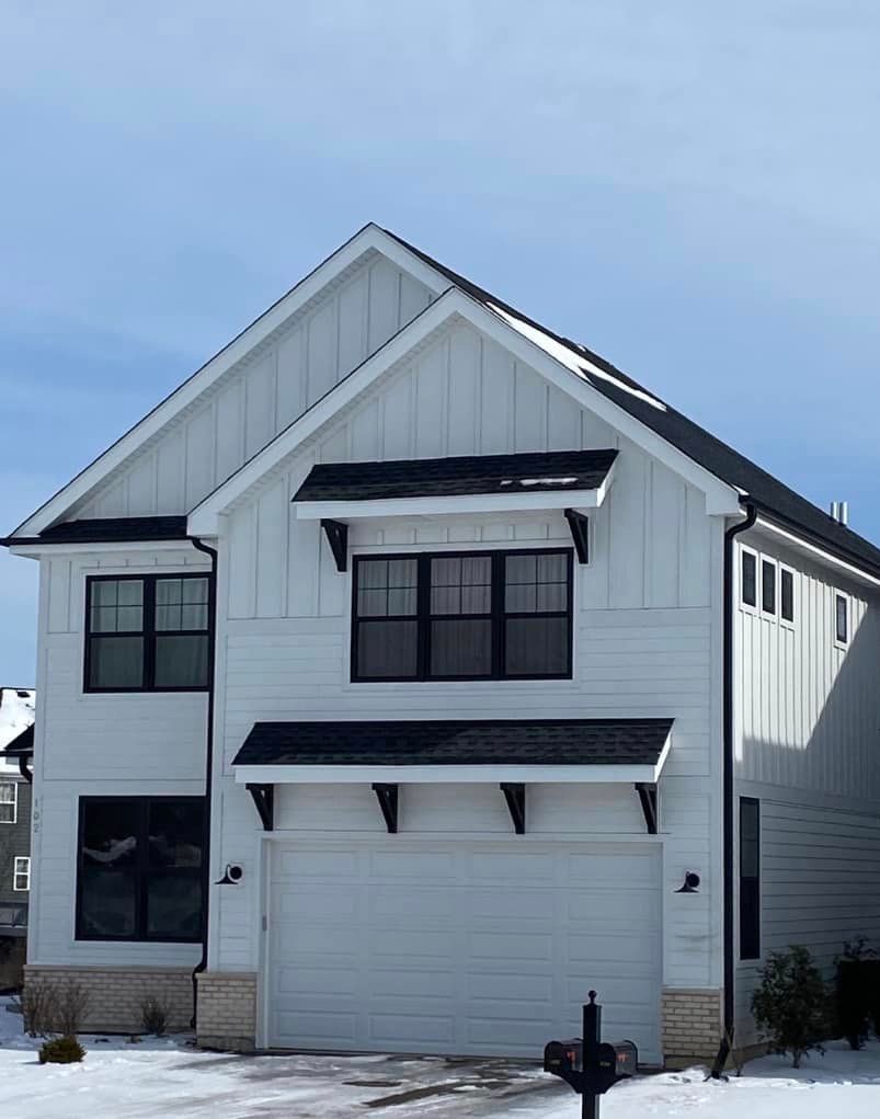 A white house with black windows and a black roof