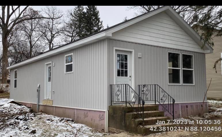 A small white house with stairs leading up to it.