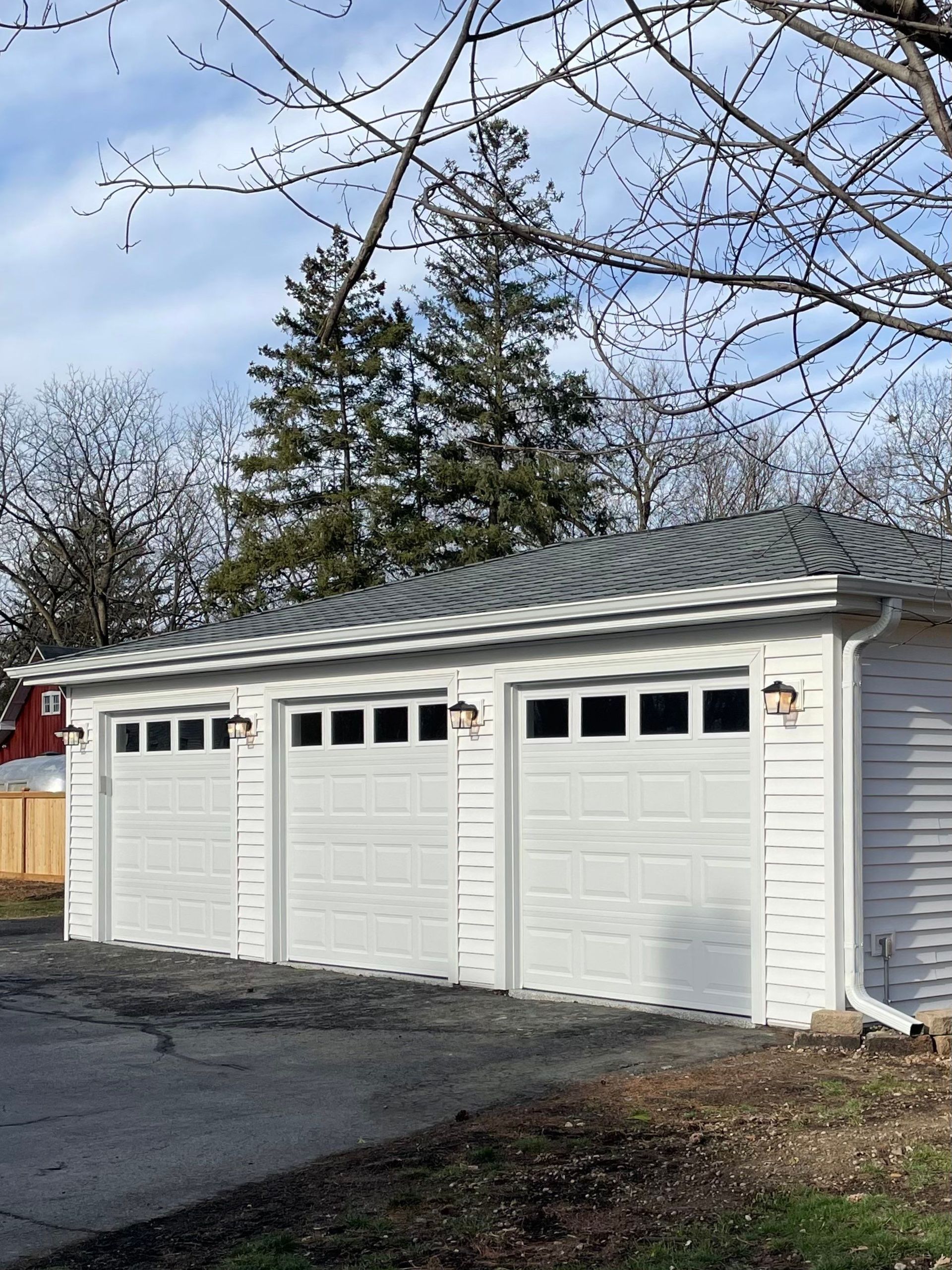 A white garage with three doors and a roof