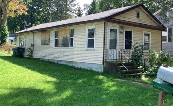 A small house with a mailbox in front of it.