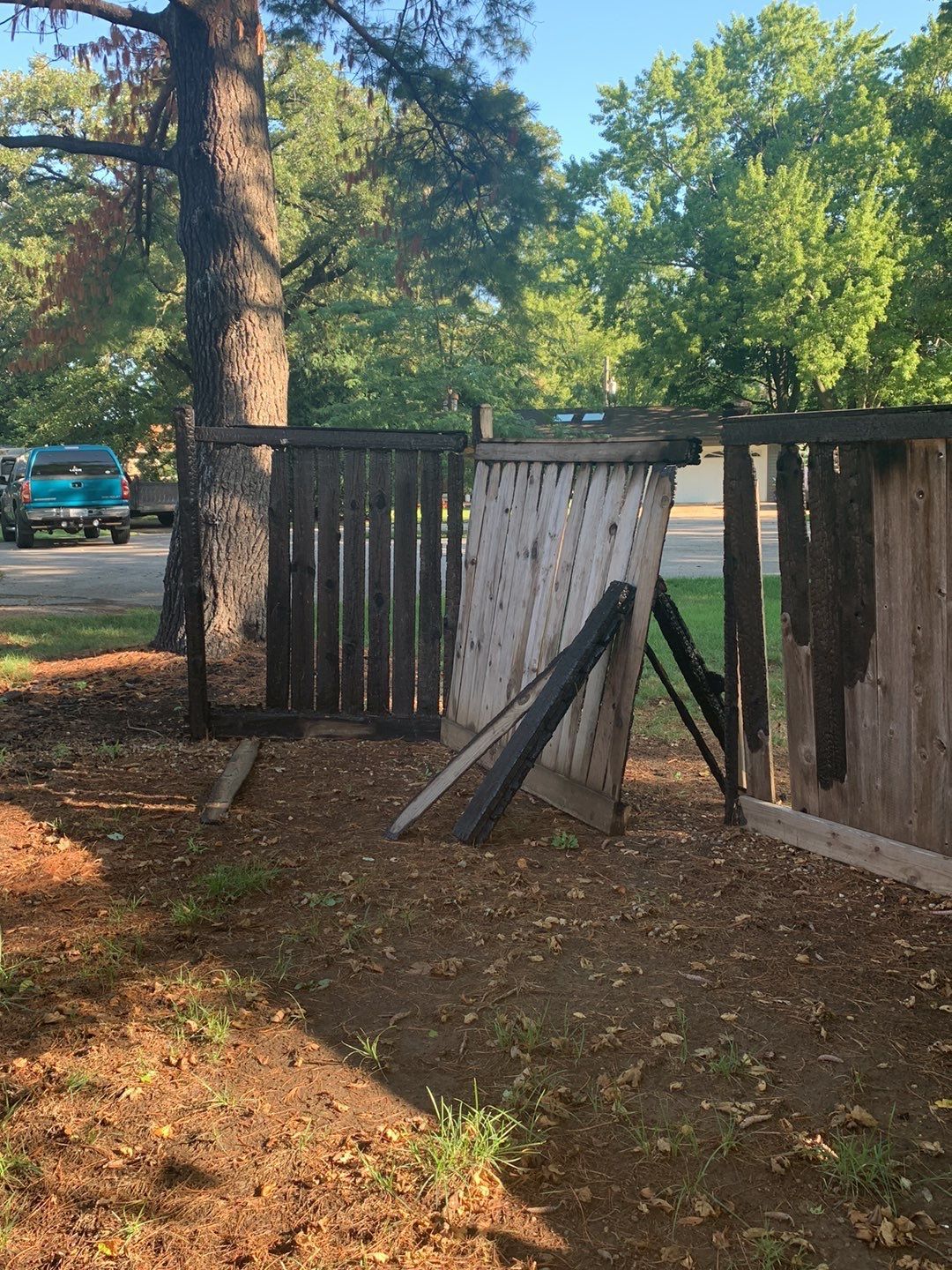 A wooden fence with a tree in the background