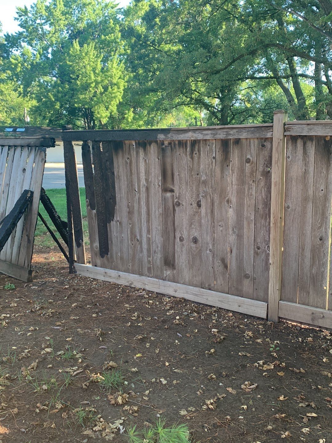 A wooden fence is sitting on top of a dirt field.