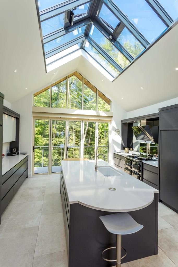 A kitchen with a large island and a skylight above it.
