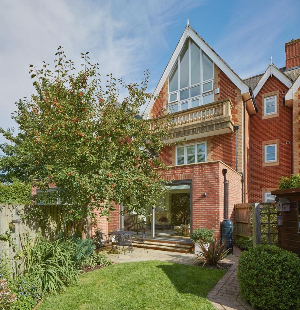 A large red brick house with a balcony and a large window