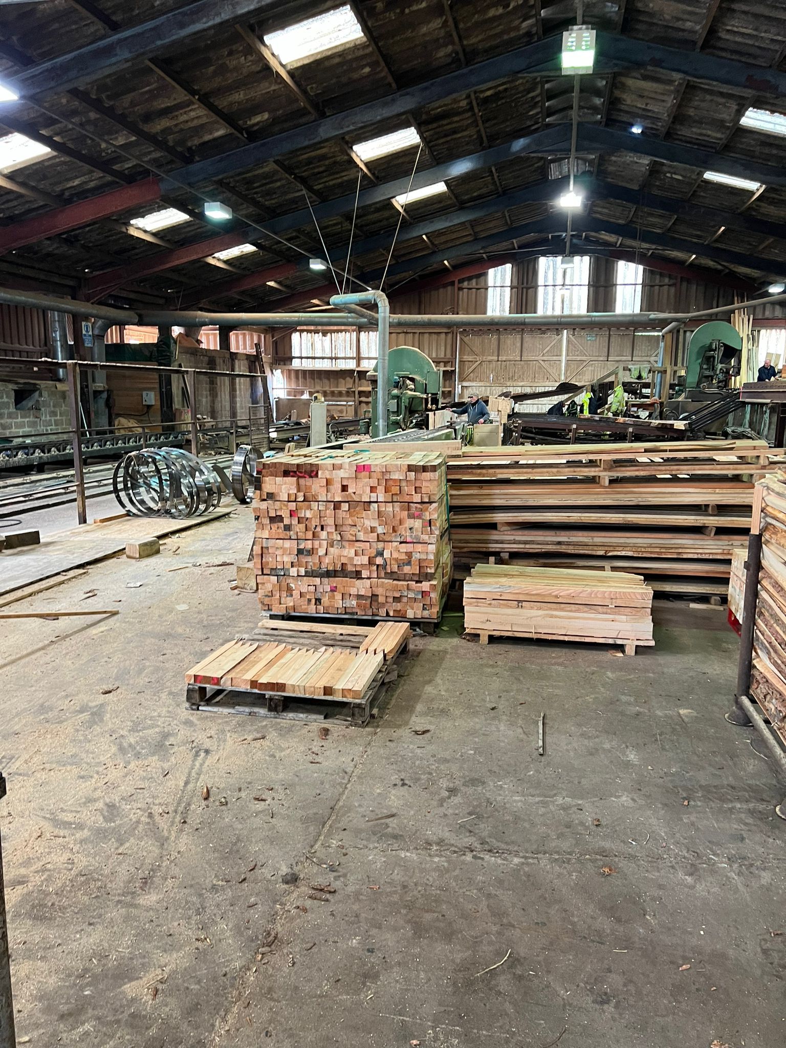 A large warehouse filled with lots of wooden pallets.