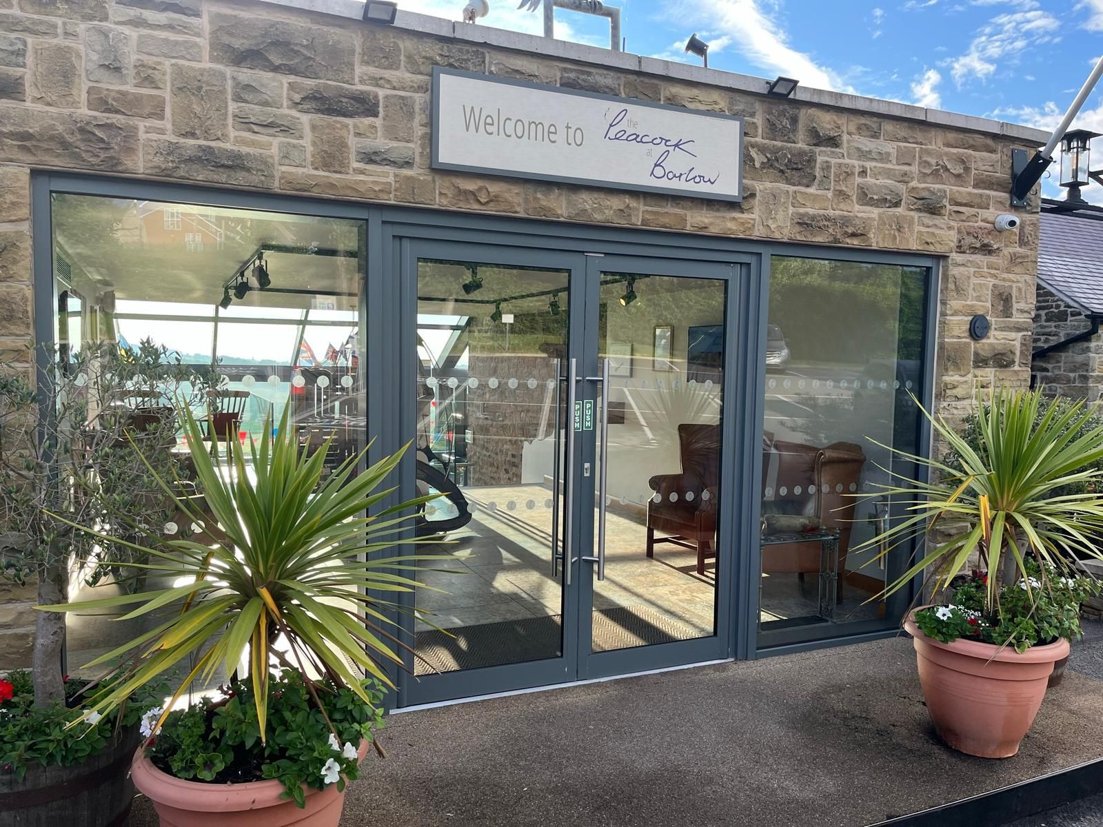 A building with a lot of windows and potted plants in front of it.
