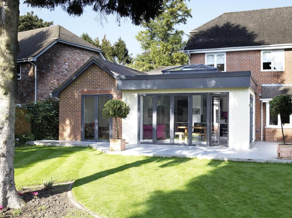 A brick house with a large sliding glass door extension