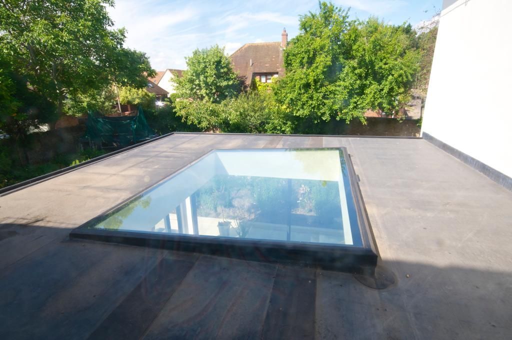 A skylight on the roof of a building with trees in the background