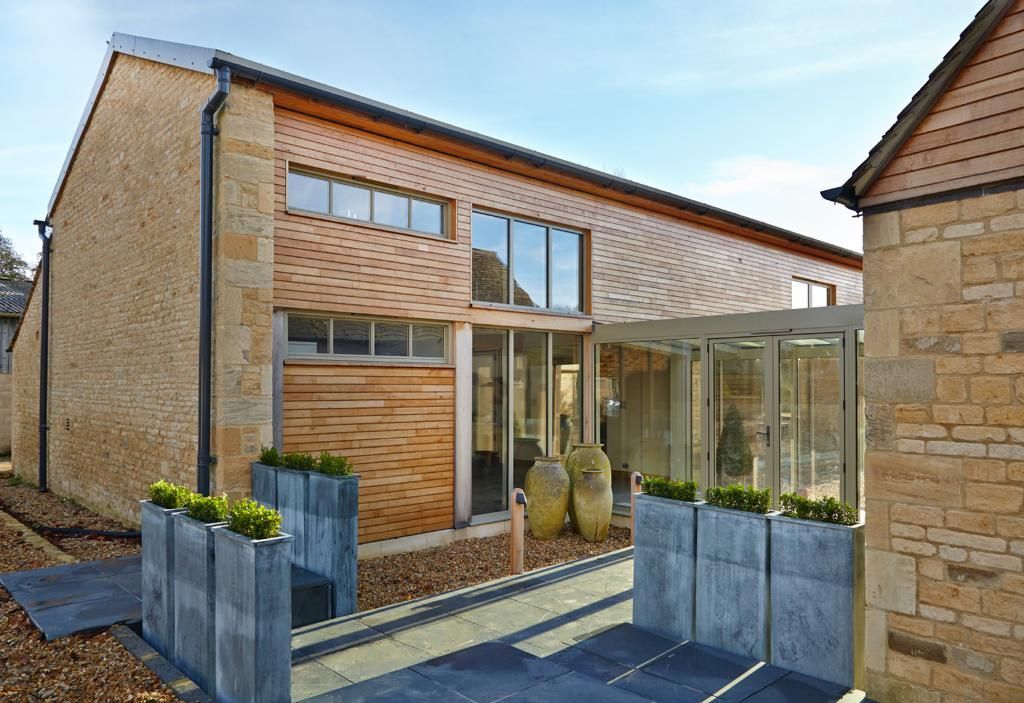 A large house with a lot of windows and planters in front of it.