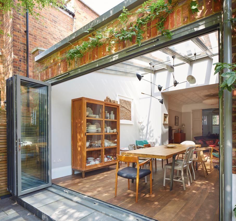 A dining room with a table and chairs and a glass door