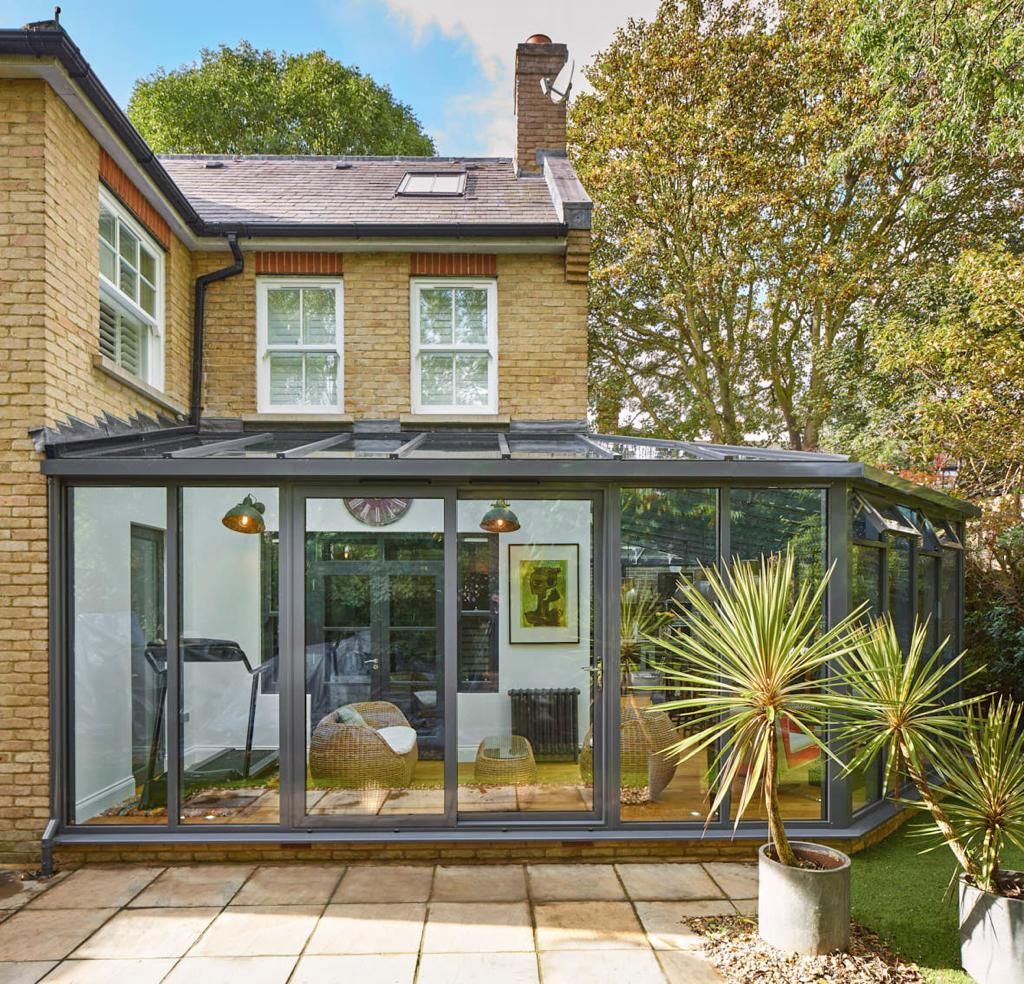 A brick house with a glass conservatory attached to it