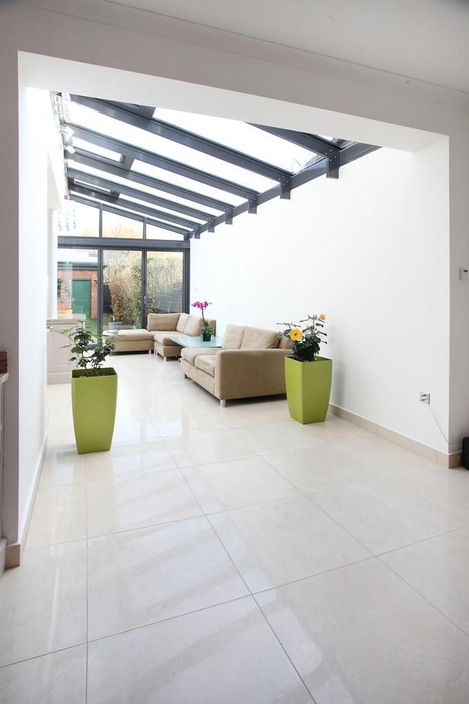 A living room with a couch and potted plants