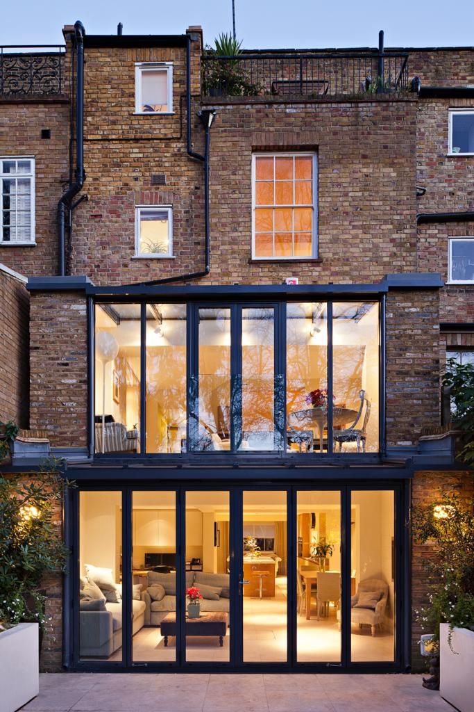 The back of a brick building with a lot of windows and doors.