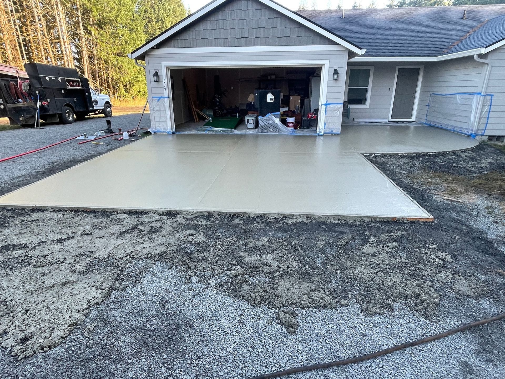 A concrete driveway is being built in front of a house.