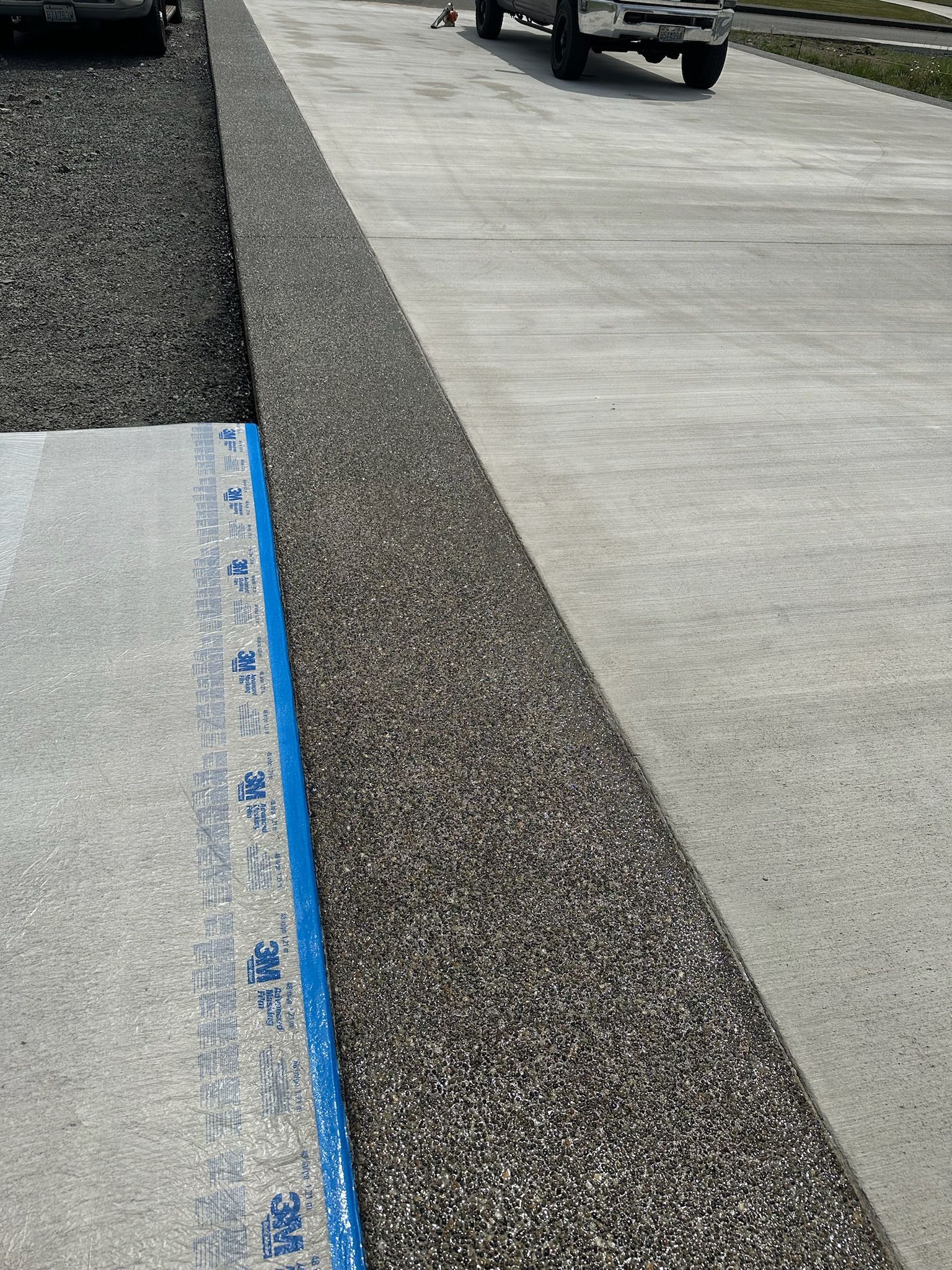 A car is parked on the side of the road next to a concrete curb.