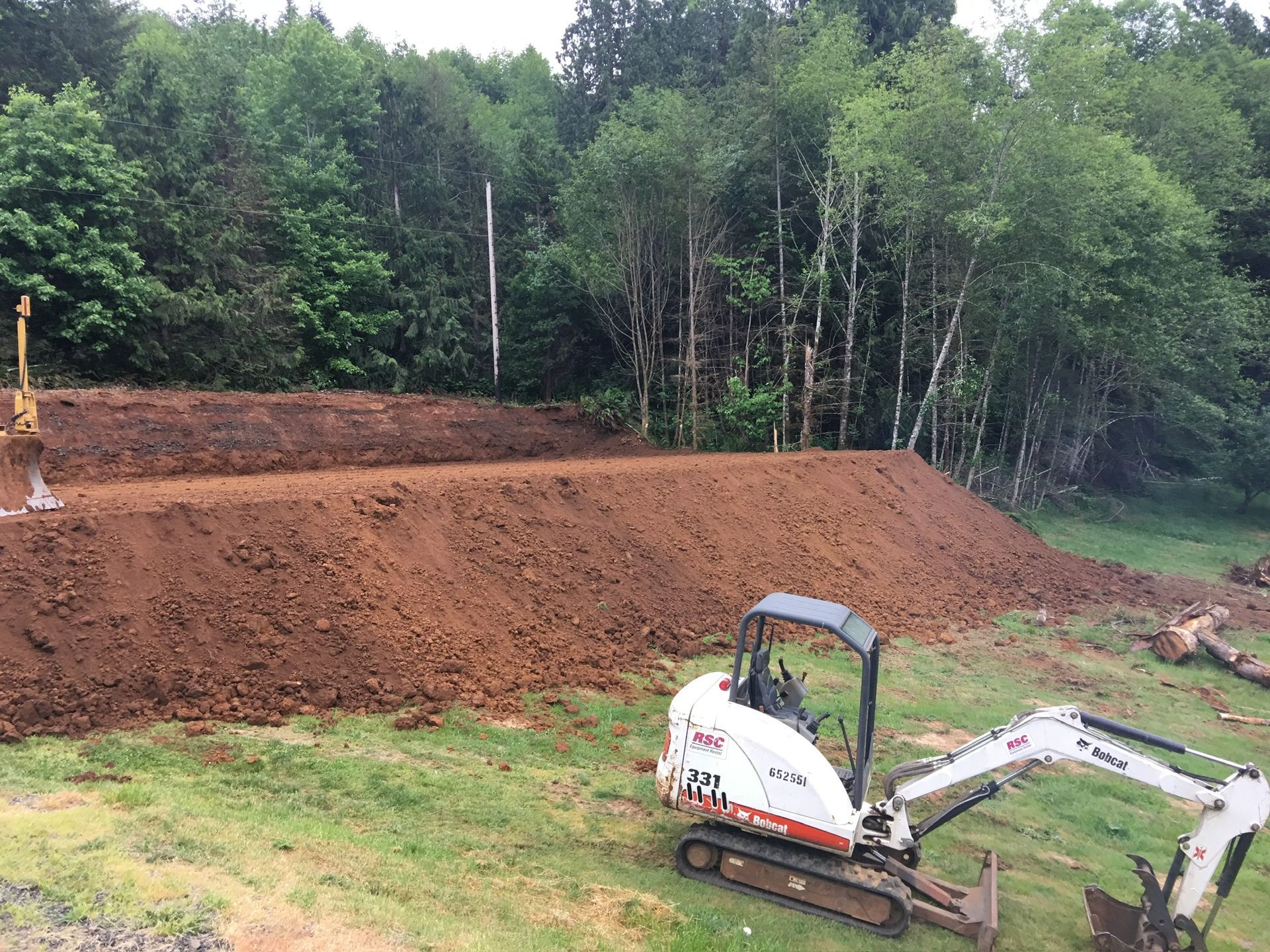 A bulldozer is sitting in the middle of a dirt field.