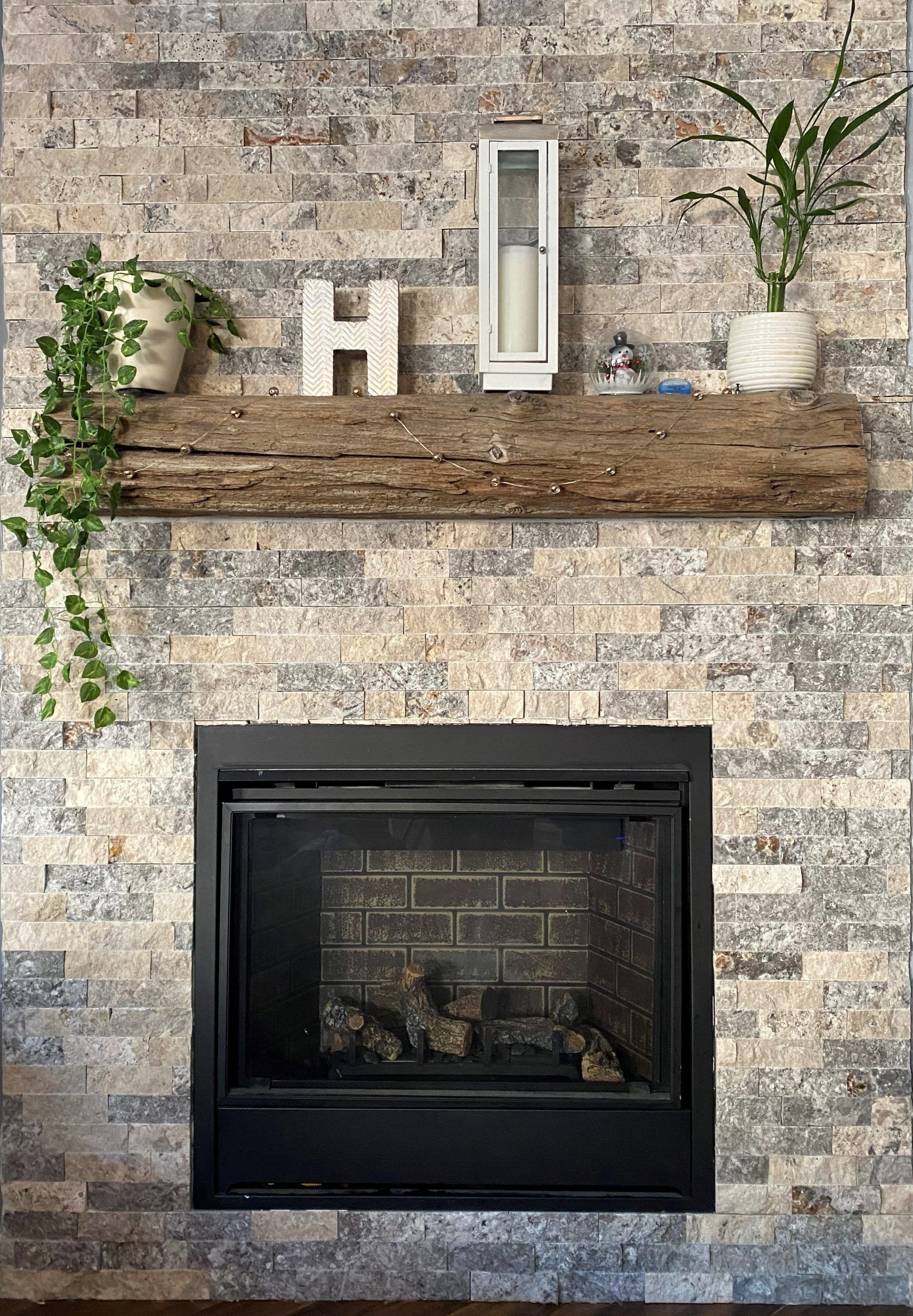 A fireplace with a wooden mantle and a brick wall.