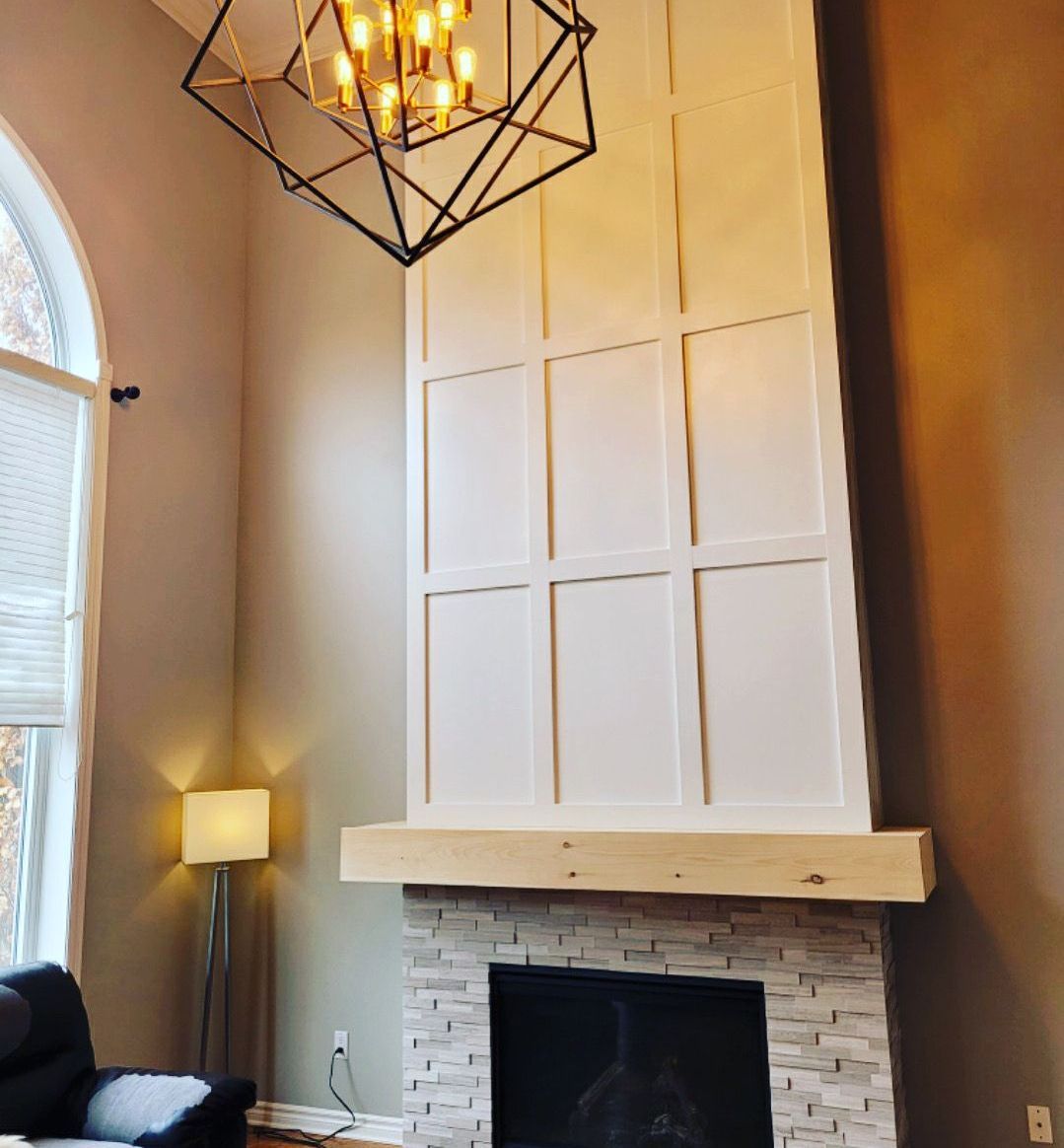 A living room with a fireplace and a chandelier hanging from the ceiling