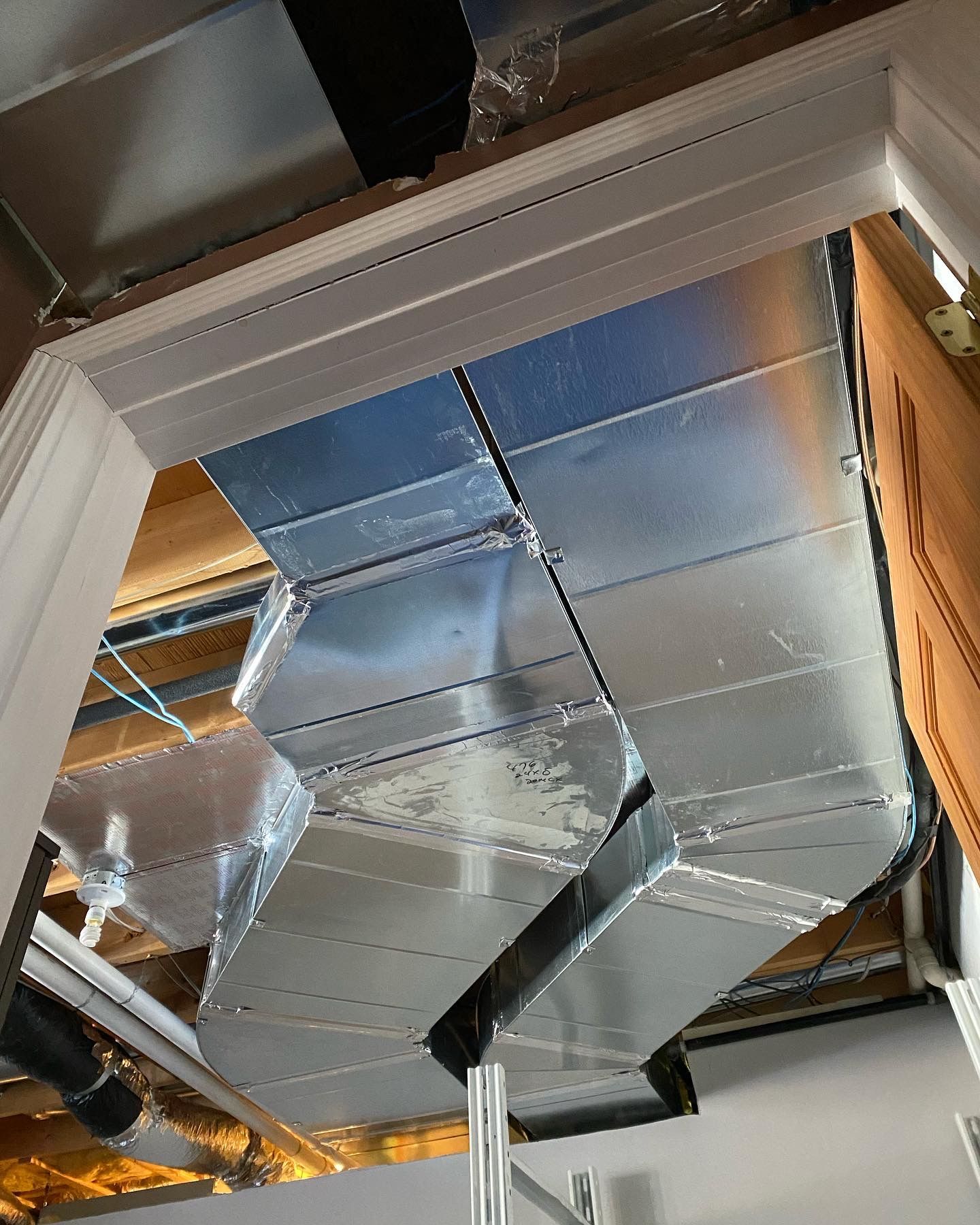 A ceiling with a lot of metal ducts coming out of it.