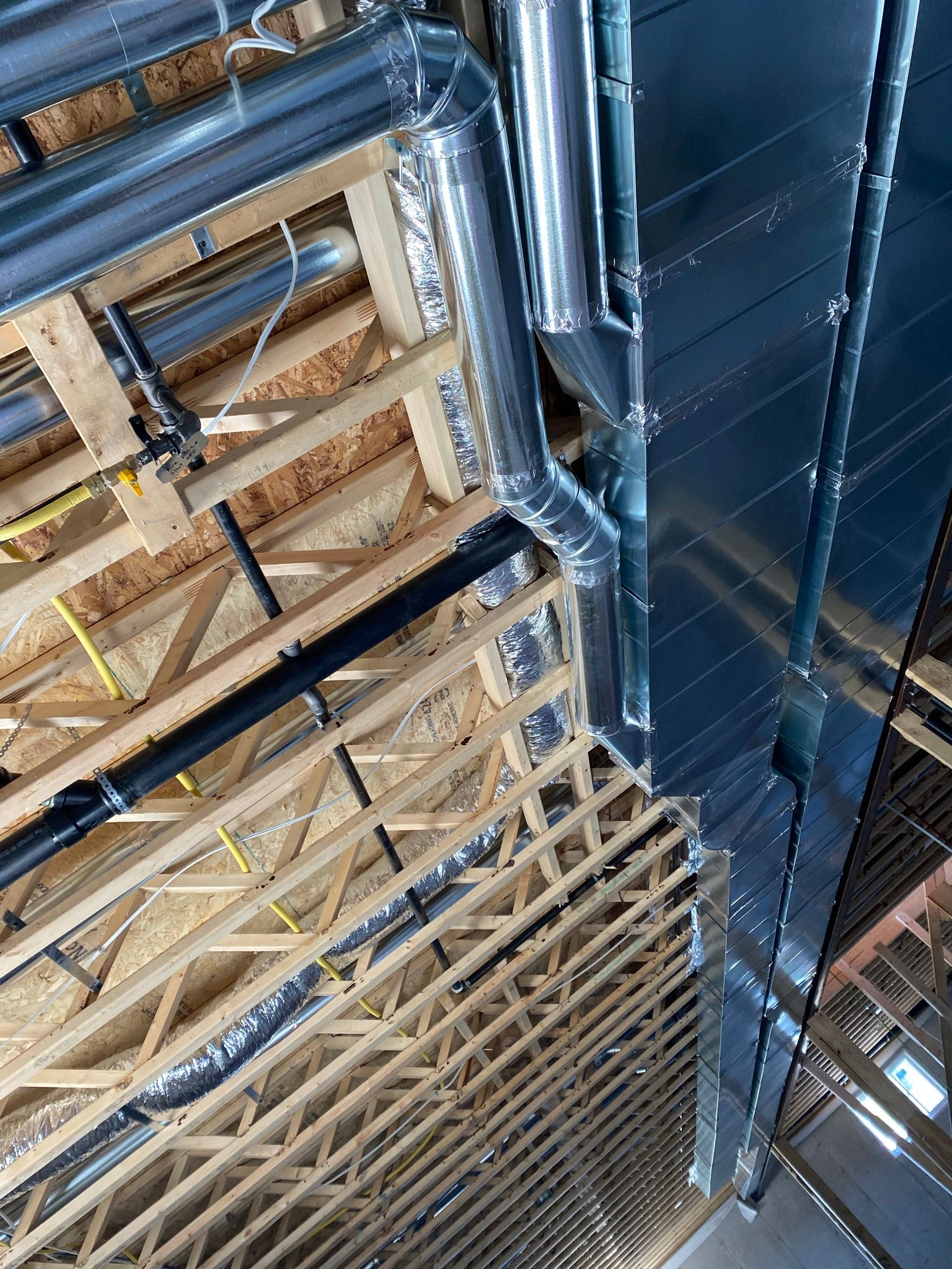 A building under construction with a lot of pipes coming out of the ceiling.