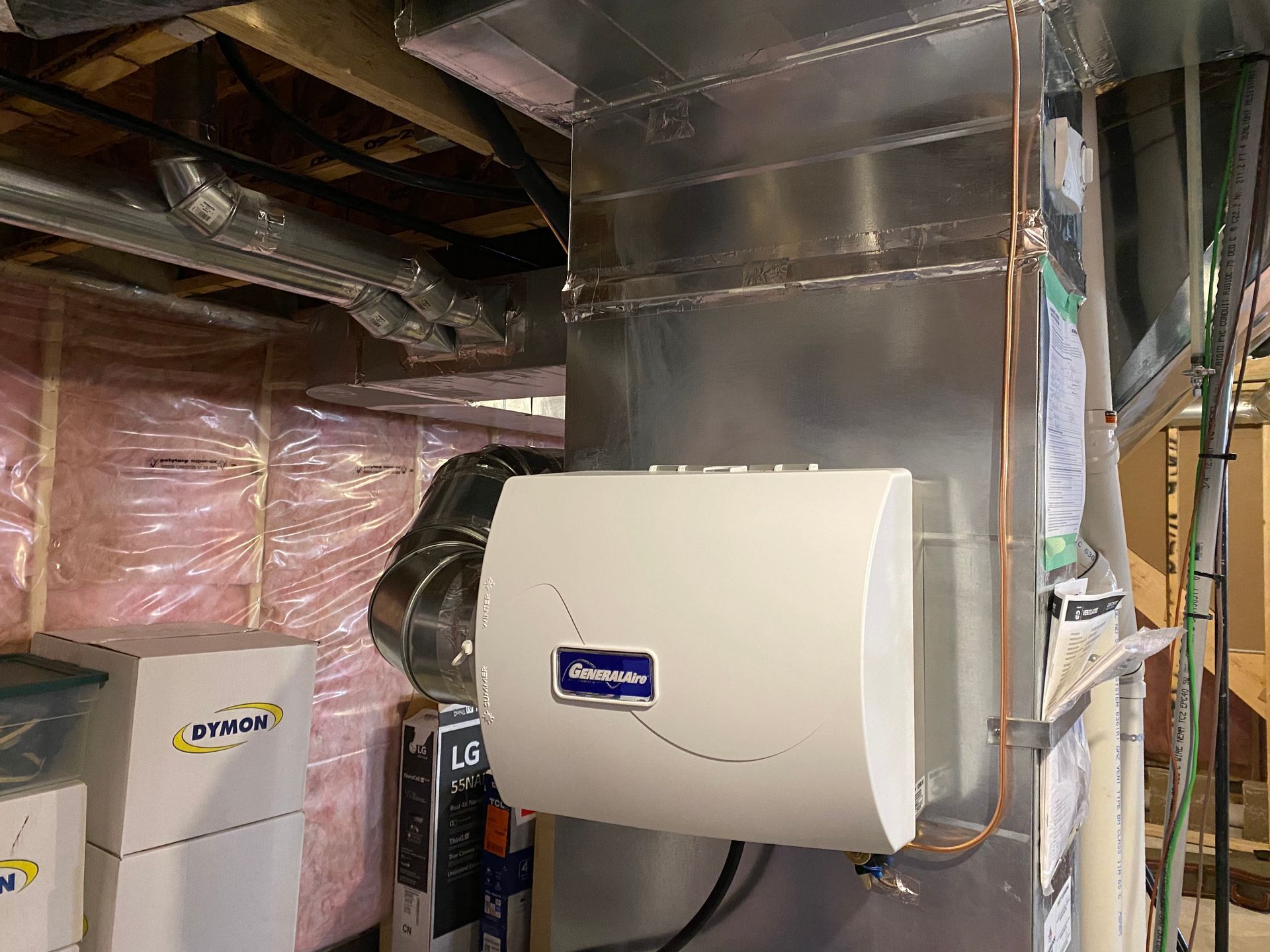 A humidifier is hanging from the ceiling of a basement.
