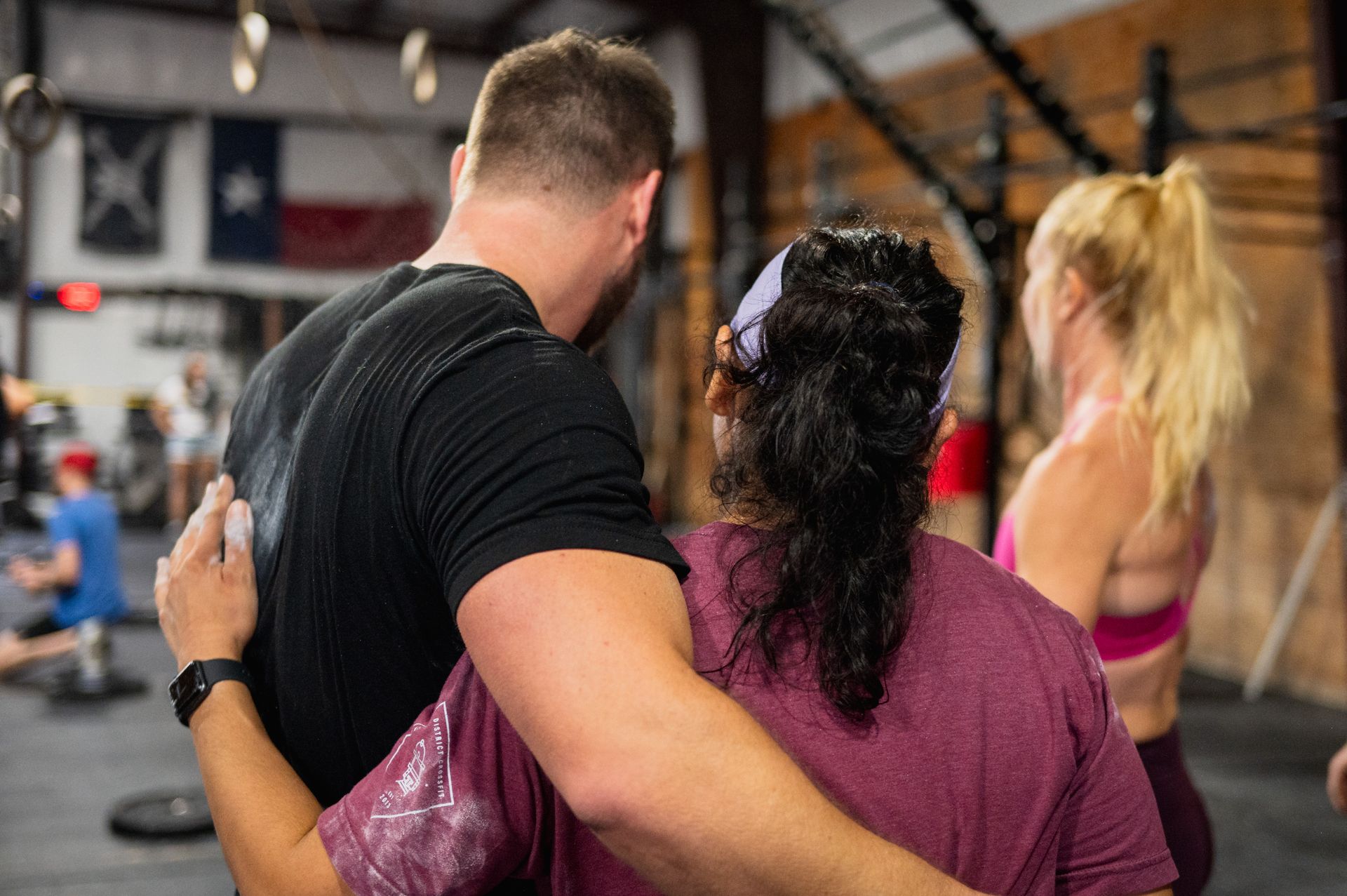A man and a woman are hugging each other in a gym.