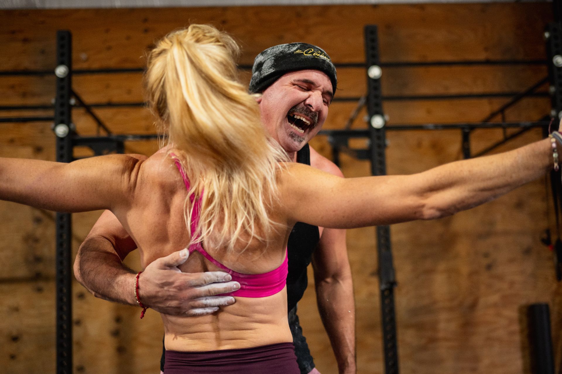 A man is hugging a woman in a gym.