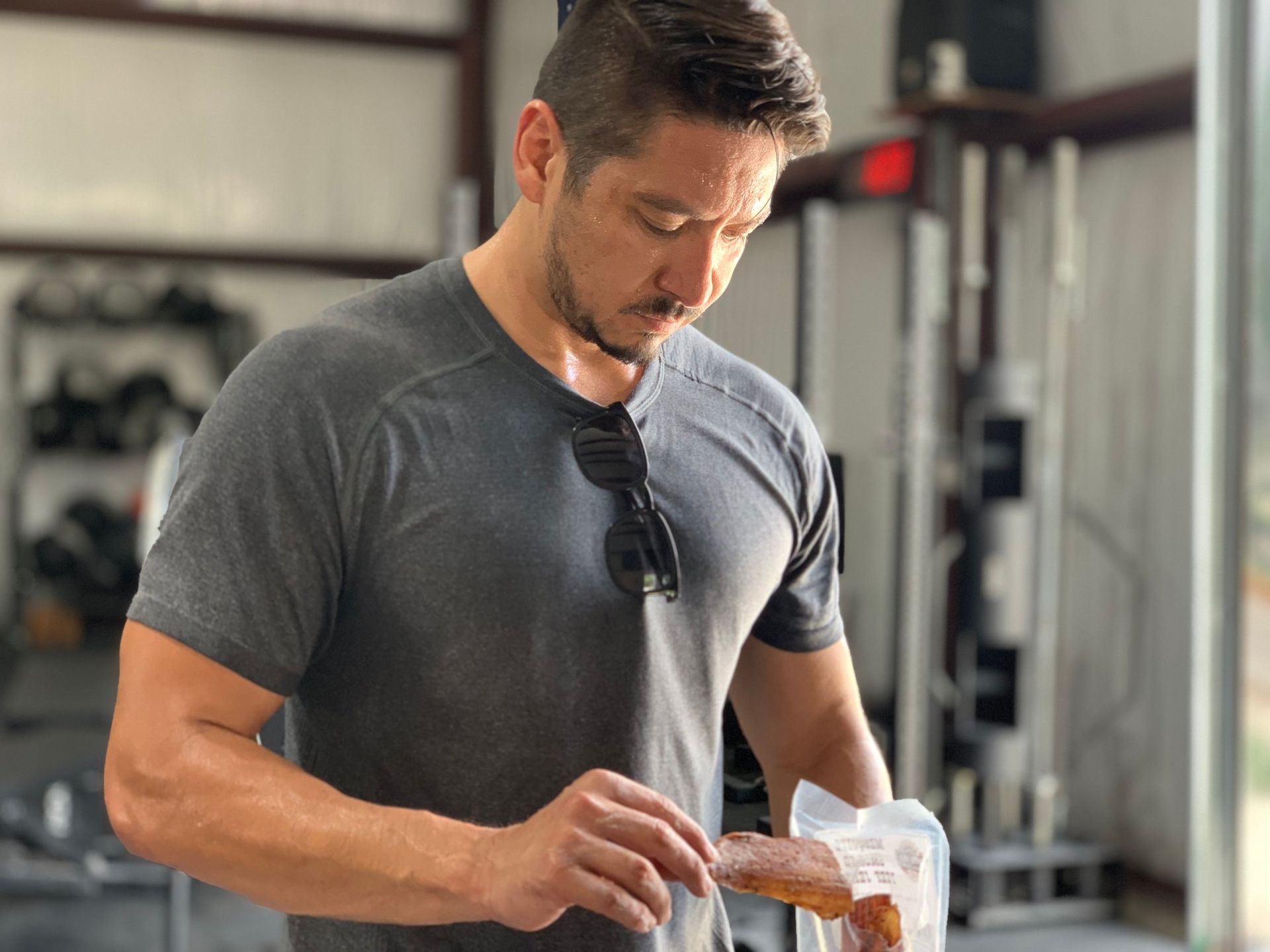 A man is holding a bag of food in a gym.